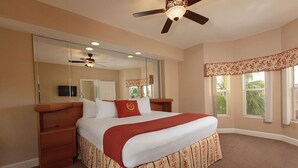 A hotel room with a large bed, a ceiling fan, a large mirror, and a window with a view of palm trees. - 7 Days / 6 Nights Gateaway (Kissimmee)