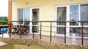 A balcony with a tiled floor, a metal railing, and a table with chairs. - Adam & Eva (Zatoka)