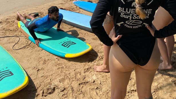 Una playa con tablas de surf y gente preparándose para surfear.