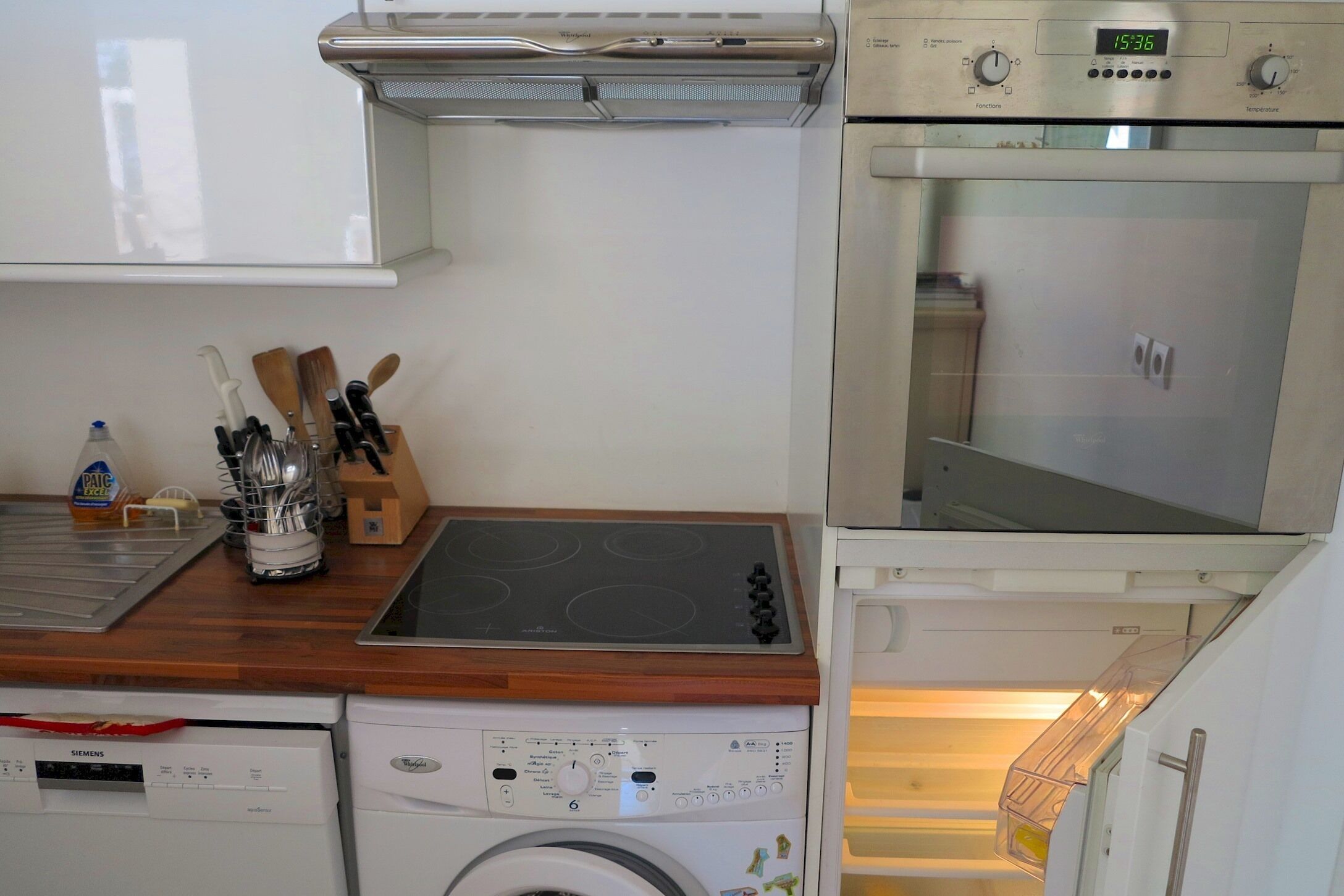 A compact kitchen with a Siemens dishwasher, a built-in oven, and a microwave.