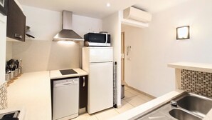 A compact kitchen with a dishwasher, a microwave, and a refrigerator. - Viva Riviera 2 Bedrooms 2 Bathrooms Rue Florian (Cannes)