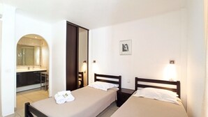 A hotel room with two single beds, a bathroom, and a kitchenette. - Viva Riviera 2 Bedrooms 2 Bathrooms Rue Florian (Cannes)