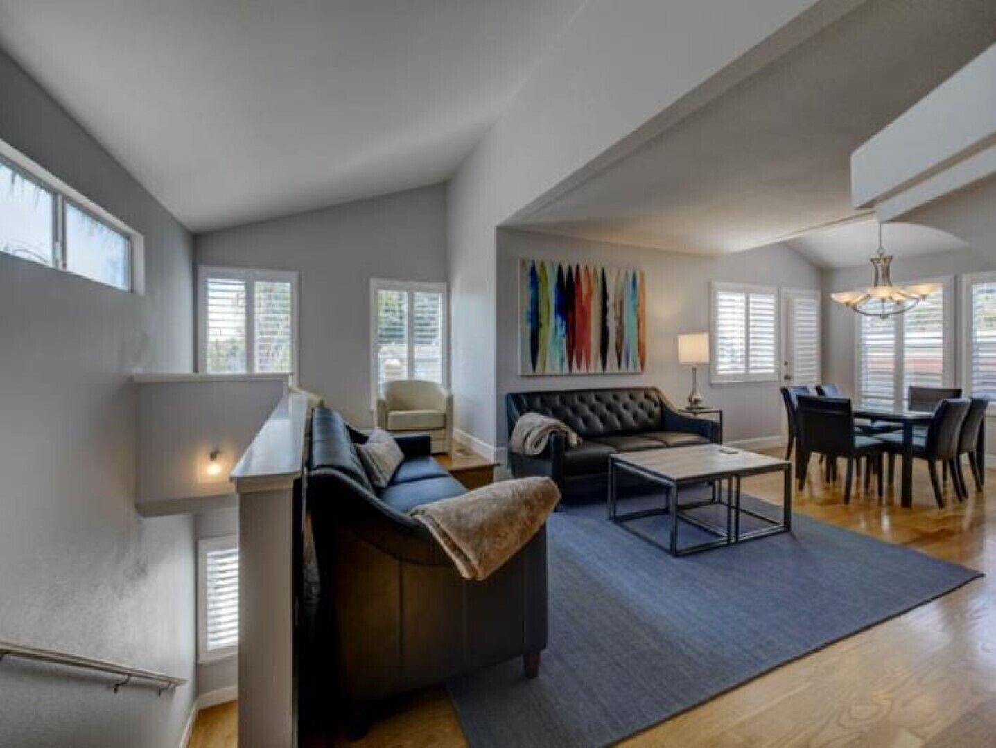 A modern living room with a sofa, coffee table, and dining area.