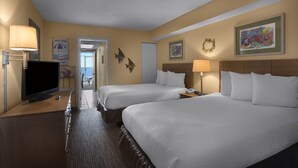 A hotel room with two beds, a TV, a desk, and a door leading to a balcony.