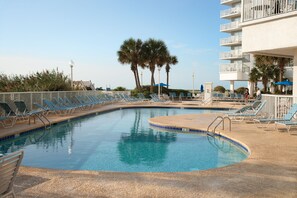 A pool area with lounge chairs and a building with balconies. - Oceanfront Suite w/ Incredible View + Official On-Site Rental Privileges (Myrtle Beach)