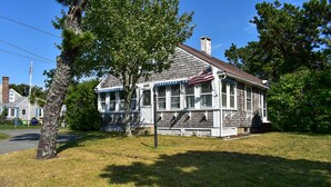 A two-story building with a porch, a flag, and a chimney. - Dennis Port beach home less than two tenths of a mile to Haigis public beach (Dennis Port)