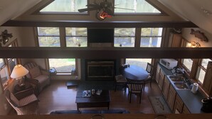 Un vaste espace de vie de style loft, doté d’un plafond haut, de grandes fenêtres, d’une cheminée, d’un coin repas et d’une cuisine équipée d’un évier et d’un four à micro-ondes.