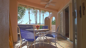 Enjoy a serene outdoor space with a table and chairs overlooking the surrounding palm trees and mountains.