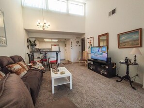 Relax in this stylish living area with a sofa, flat-screen TV, and dining set.