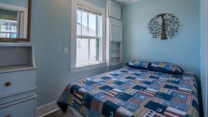 A bedroom with a bed, a dresser, a window, and a wall-mounted tree decoration. - Ocean Breezes at Salty Air Suites, Suite C – New Balcony, 3BR, walk to the Beach (Old Orchard Beach)