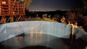 A swimming pool with a wooden deck and a view of a cityscape at night. - Typical Tuscan Residence near the farm la Vialla (Ponina)