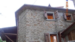 A stone building with multiple windows and a wooden door. - Typical Tuscan Residence near the farm la Vialla (Ponina)