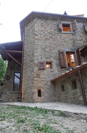 A stone building with multiple windows and a wooden door.