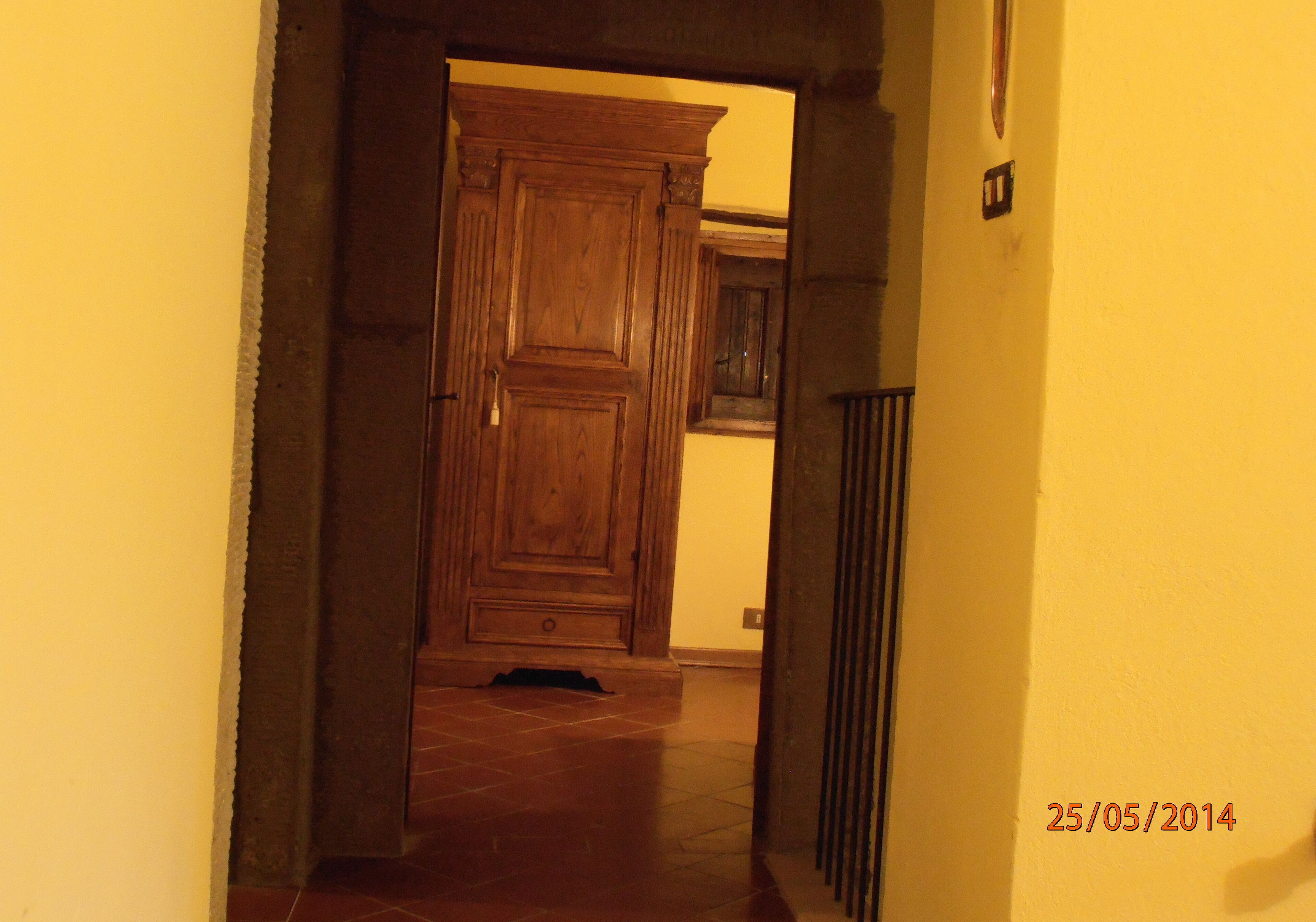 A hallway with a wooden door and a tiled floor.