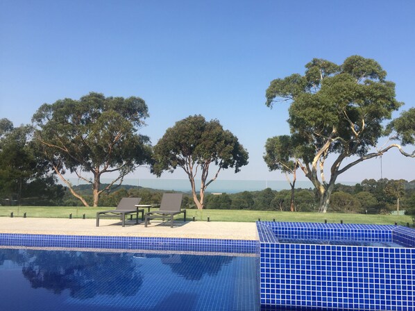 Relax by the serene pool surrounded by lush greenery and mature trees.