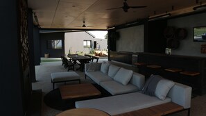 Relax in this inviting outdoor seating area with a sofa, dining table, and coffee table.