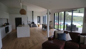 Een ruime woonkamer met een groot raam, een open haard en een eethoek.
