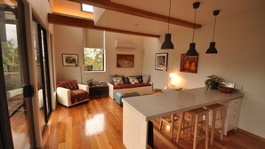 Una cocina moderna con una isla central, suelo de madera e iluminación colgante.