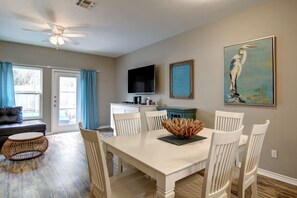 Enjoy meals in this dining area with a table and six chairs, a flat-screen TV, and a beautiful painting.