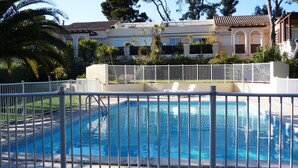 A rectangular swimming pool with a white metal fence in the foreground. - ST RAFAEL-BOULOURIS, seaside, great appartment 2room, ground floor (St. Rafaël - Boulouris)