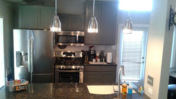 A kitchen with granite countertops, stainless steel appliances, pendant lighting, and a window with blinds. - Your Retreat in Austin - Relax & enjoy free Netflix movies Pet Stays for Free ! (Austin)