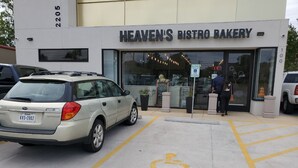 A building with a sign reading "HEAVEN'S BISTRO BAKERY" and a handicapped parking sign. - Your Retreat in Austin - Relax & enjoy free Netflix movies Pet Stays for Free ! (Austin)