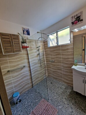 Un baño con ducha, lavamanos e inodoro.