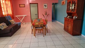 Un salon comprenant un canapé, une table à manger, des chaises et un meuble.