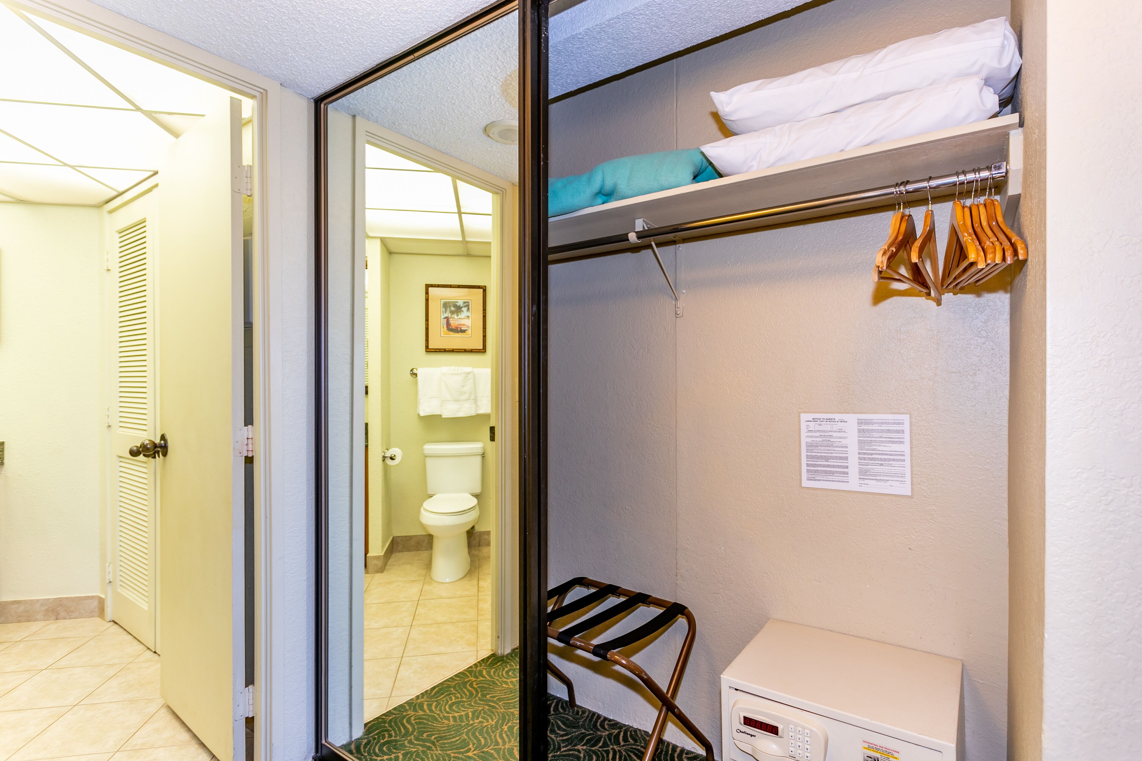Een hotelbadkamer met een toilet, een handdoekhouder en een bericht voor gasten.