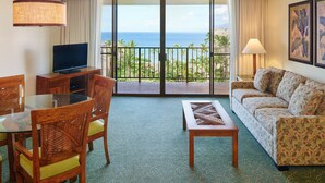 A hotel room with a balcony, a television, a dining table with chairs, and a sofa. - Oceanview Retreat  | Aston Ka'anapali Shores 1BO5 – Pool, Hot Tub & Spa (Kaanapali)
