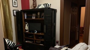 Ein Wohnzimmer mit einer Couch, einer Holzeinrichtungsanlage und einer roten Säule.
