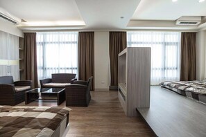 A modern hotel room with a large bed, a sofa, a TV, and a wardrobe. - 917 Homestay (Magong)