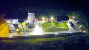 A multi-story house with a central cylindrical tower, a driveway, and a landscaped garden. - 917 Homestay (Magong)