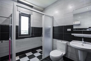 A modern bathroom with a black and white checkered floor, a white toilet, a sink with a mirror, and a shower with a sliding door. - 917 Homestay (Magong)