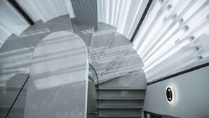 A modern interior with a spiral staircase, a glass ceiling, and a circular window. - 917 Homestay (Magong)