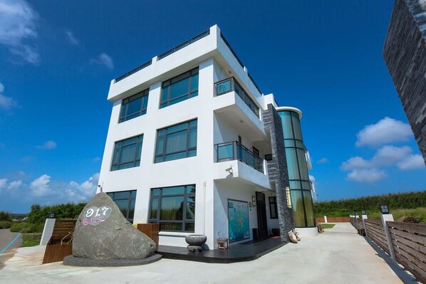 A modern two-story building with large windows and a curved glass facade. - 917 Homestay (Magong)