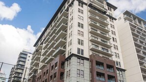 Un hôtel à plusieurs étages doté d’une architecture moderne, caractérisé par une entrée imposante et un mât de drapeau.