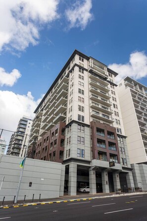 Een meerlaags hotel met een modern architectuurontwerp, met een opvallende ingang en een vlaggenmast.