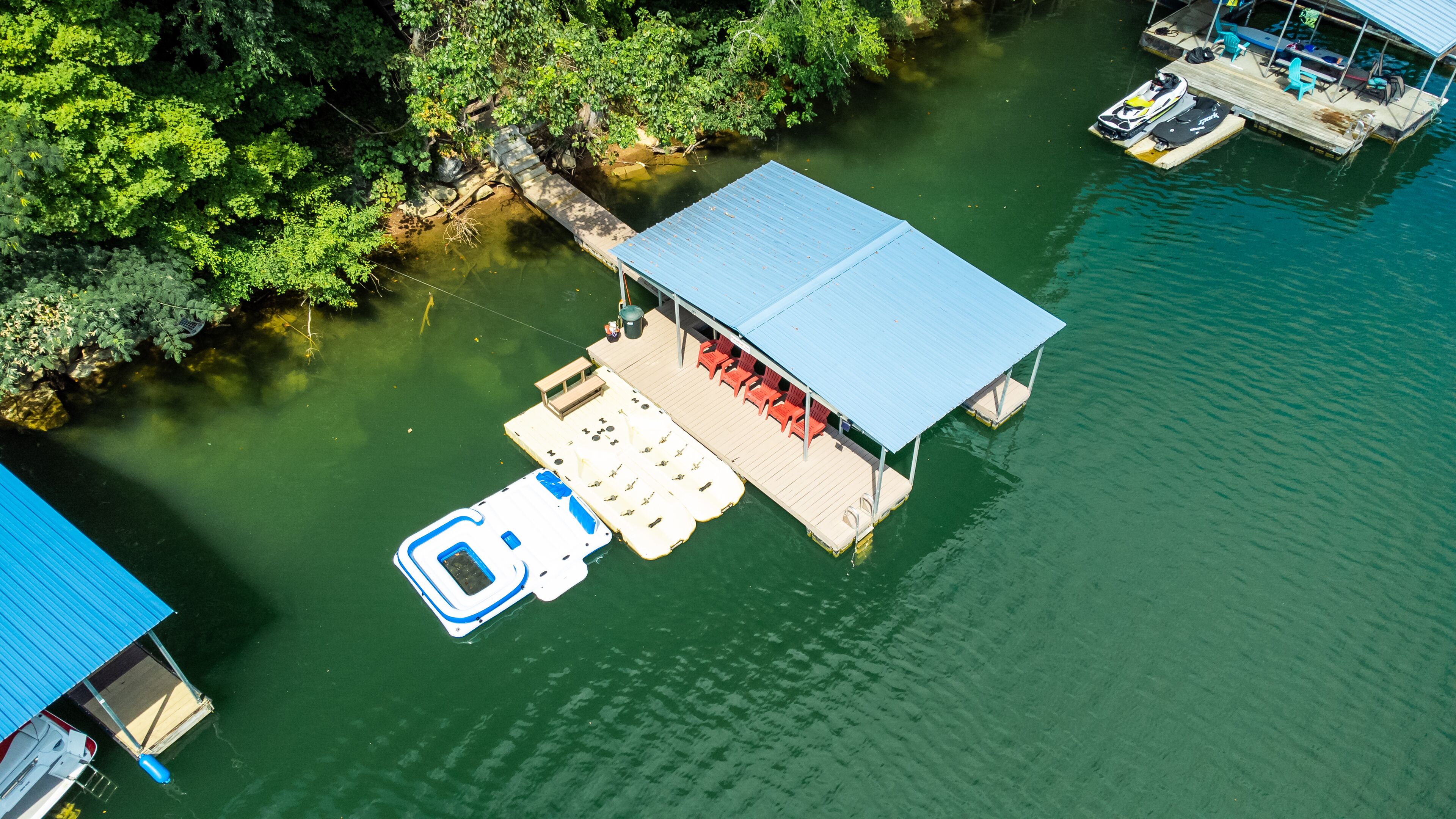 Vue aérienne d’un quai doté d’un espace de repos abrité, d’une plateforme flottante avec des sièges et d’un bateau.
