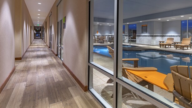 A hotel corridor with a pool area visible through large windows. - La Quinta Inn & Suites by Wyndham Flagstaff East I-40 (Flagstaff)