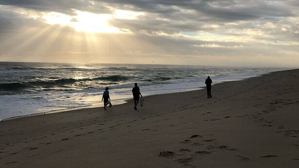 A beach with footprints, a cloudy sky, and the sun shining through the clouds. - Melbourne Beach getaway, Surfing, Birdwatching, nature. fishing. (Melbourne Beach)