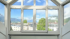 A room with a glass ceiling, a table, and two chairs. - Hotel Harder Minerva (Interlaken)