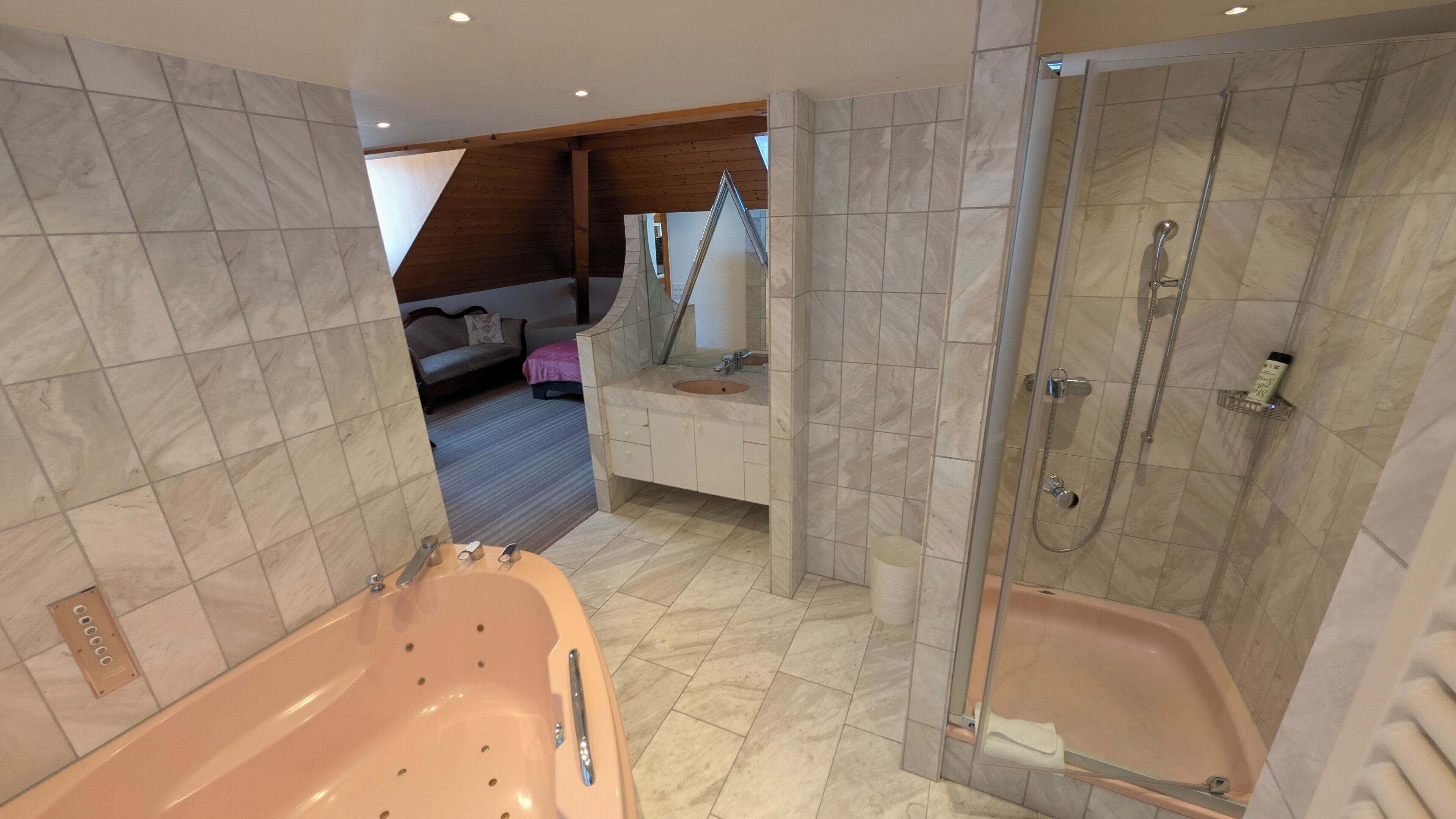 A modern bathroom with a large bathtub, a separate shower area, and a vanity with a sink and mirror.