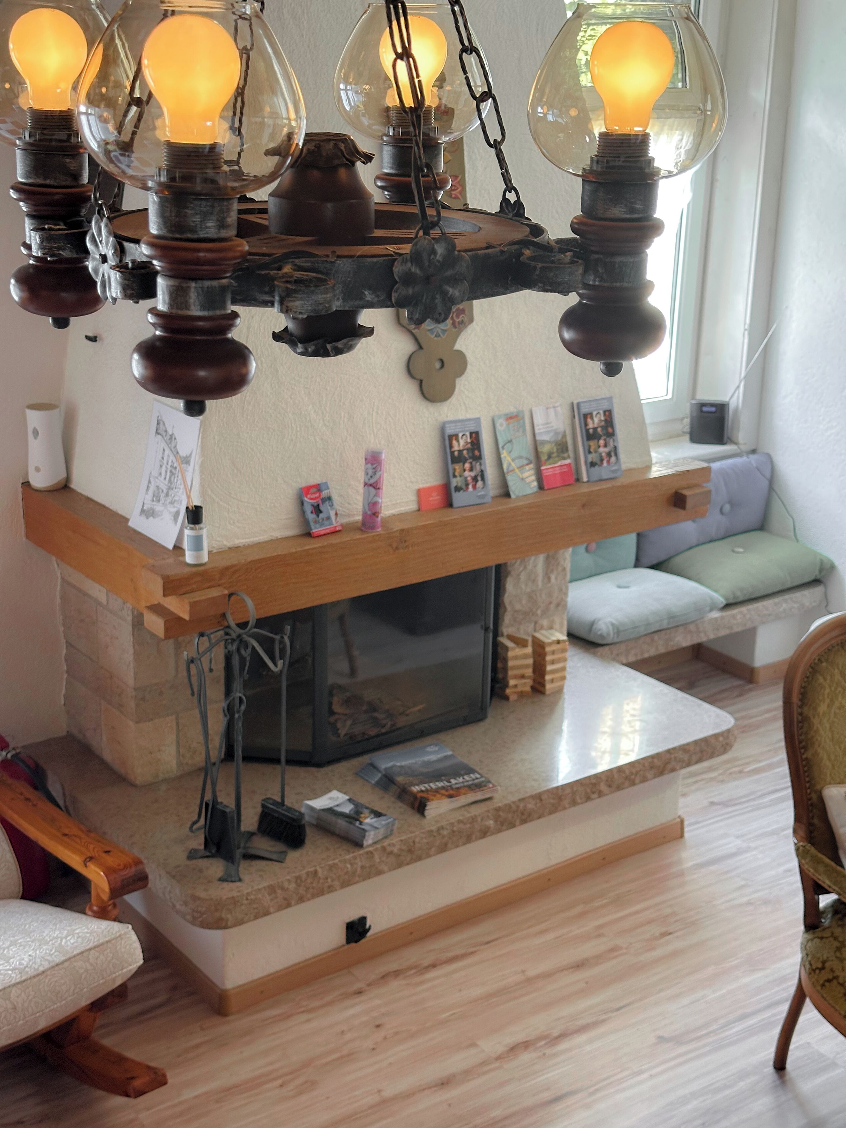 A cozy living room with a fireplace, a wooden coffee table, and a seating area with cushions.