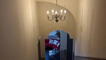Een trap die leidt naar een kamer met een rode bank en een witte kast.
