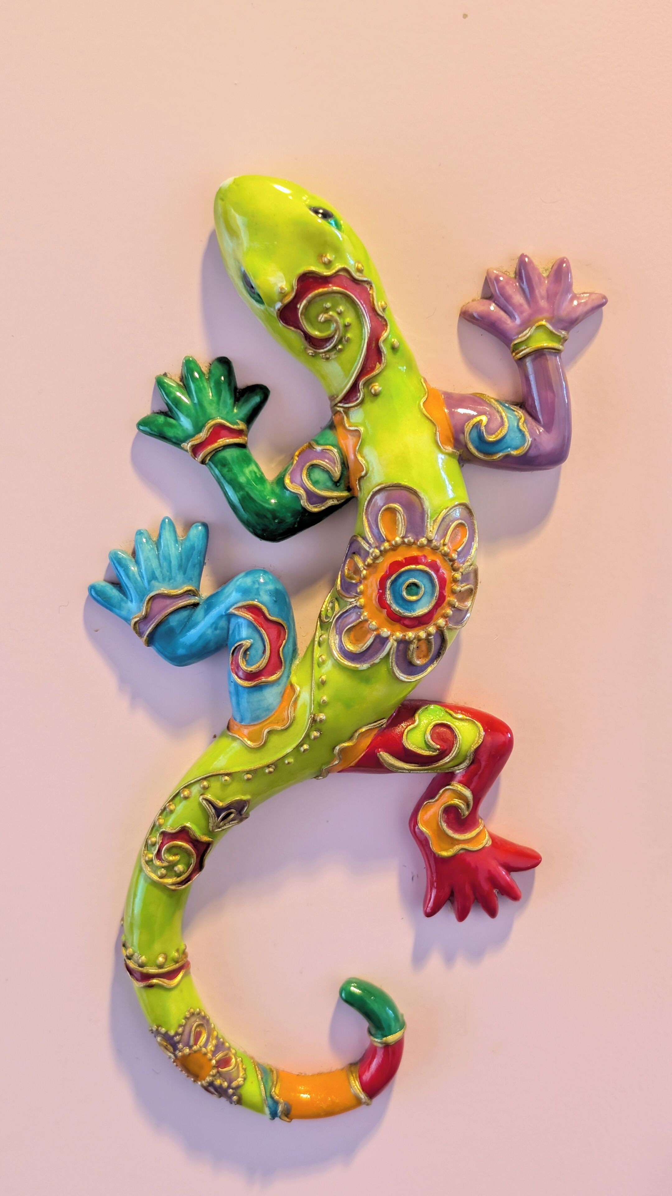 A colorful lizard sculpture with intricate patterns and designs.