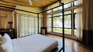 A hotel room with a bed, a ceiling fan, large windows, and curtains. - Amatapura Beach 6 (Sai Thai)