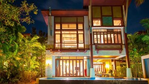 A two-story building with large windows and a swimming pool in front. - Amatapura Beach 6 (Sai Thai)