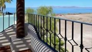 A balcony with a metal railing, a palm tree, and a view of the sea. - Casa Vista del Mar, Amazing Ocean View (Loreto)