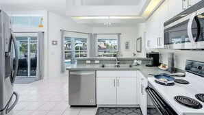A modern kitchen with a dishwasher, stove, and microwave.